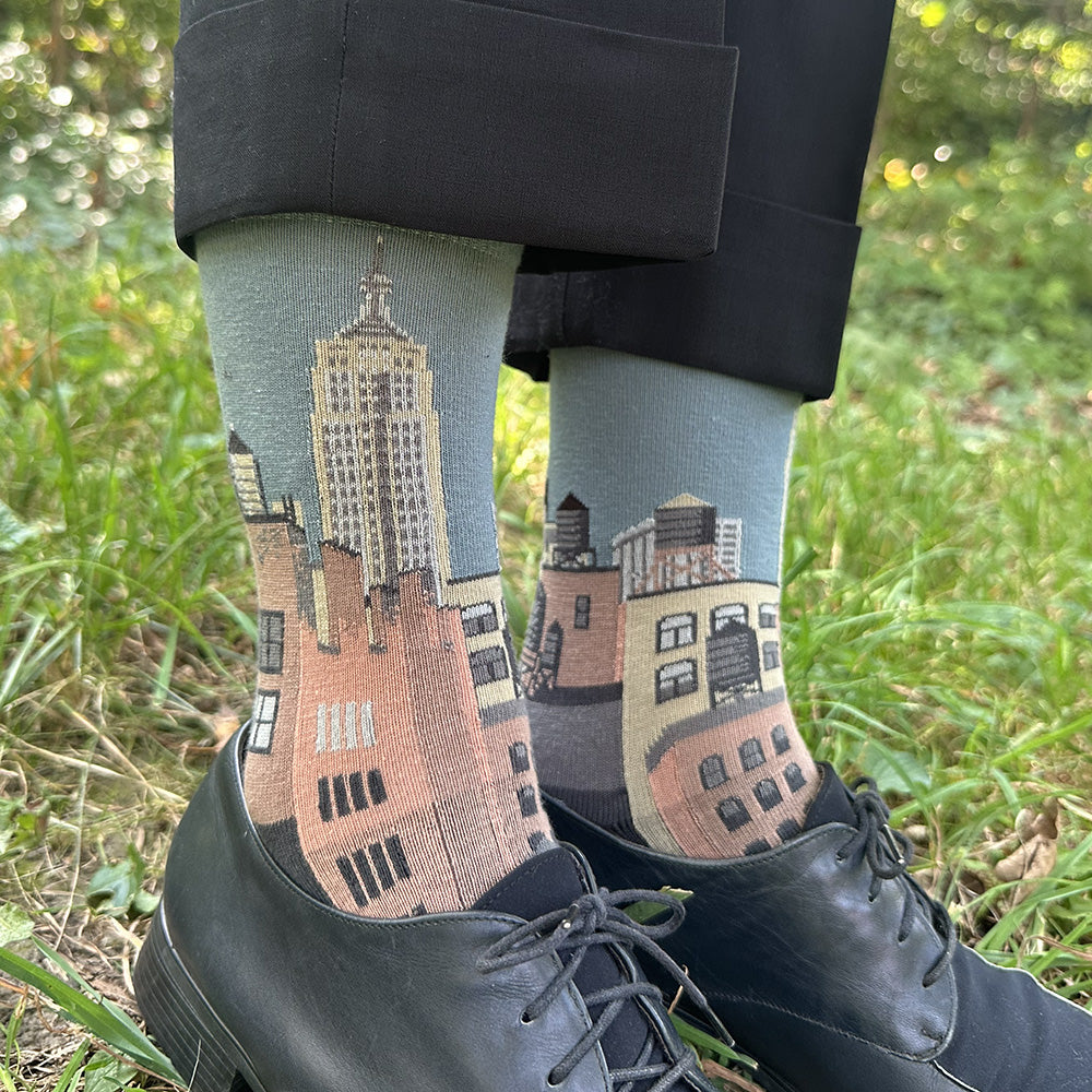 Made in USA women's cotton NYC cityscape sock featuring buildings and water towers on blue-grey sky background by THIS NIGHT