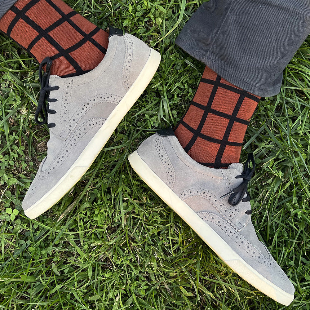 Made in USA men's geometric cotton socks in rust (brown-orange) with a black windowpane plaid grid pattern by THIS NIGHT