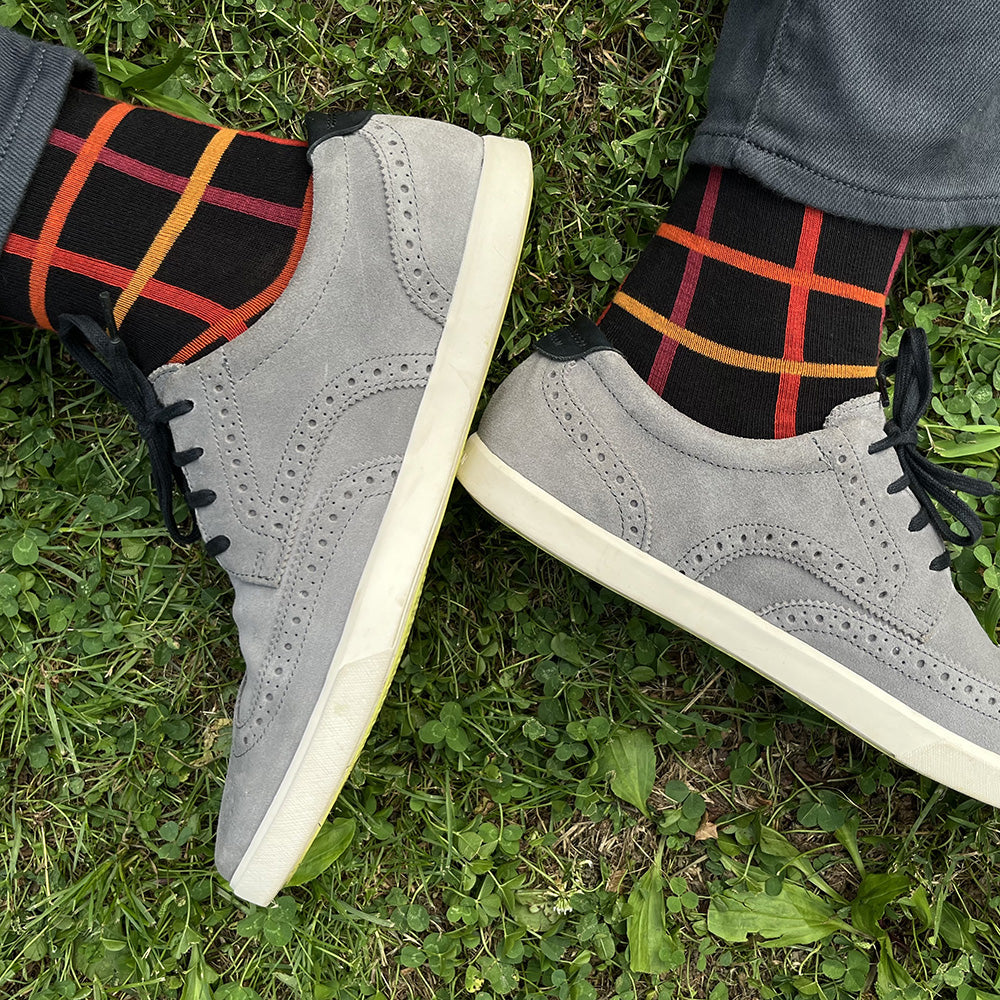 Made in USA men's black cotton geometric socks with oranges, yellows, and reds in a windowpane plaid/grid pattern by THIS NIGHT