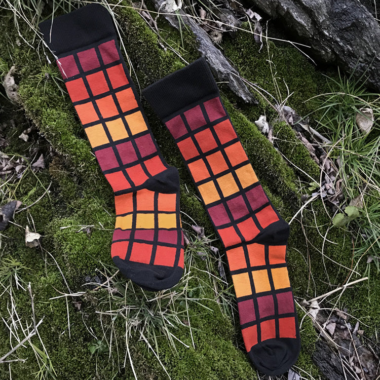 MADE IN USA men's black geometric cotton socks inspired by R62A NYC Subway car with maroon, paprika, orange, + yellow-orange pattern